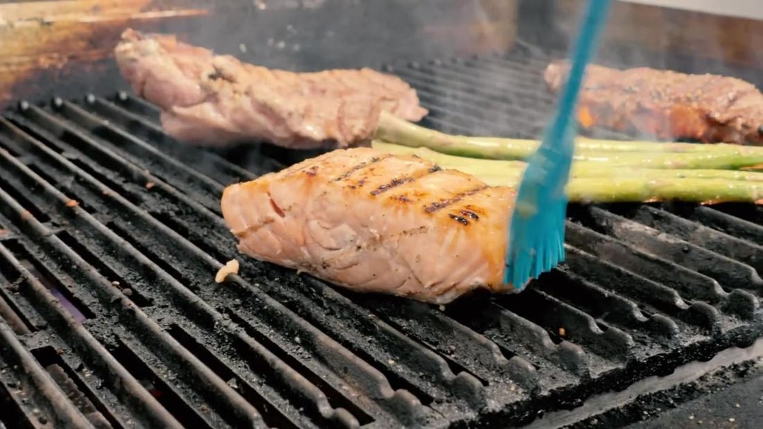 Steaks being basted on the grill in the Steak & Take kitchen